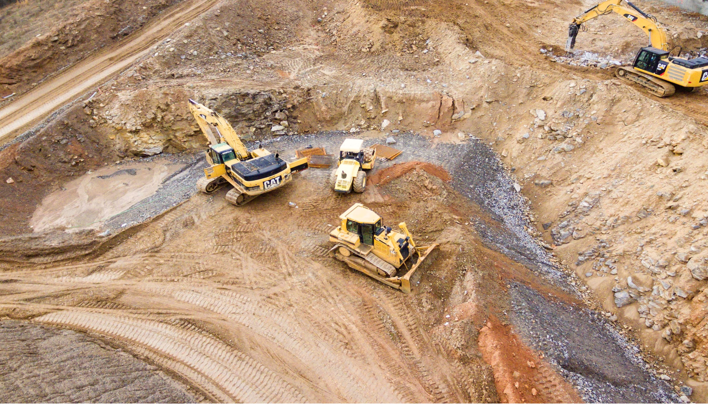 Heavy machinery hauling away dirt.