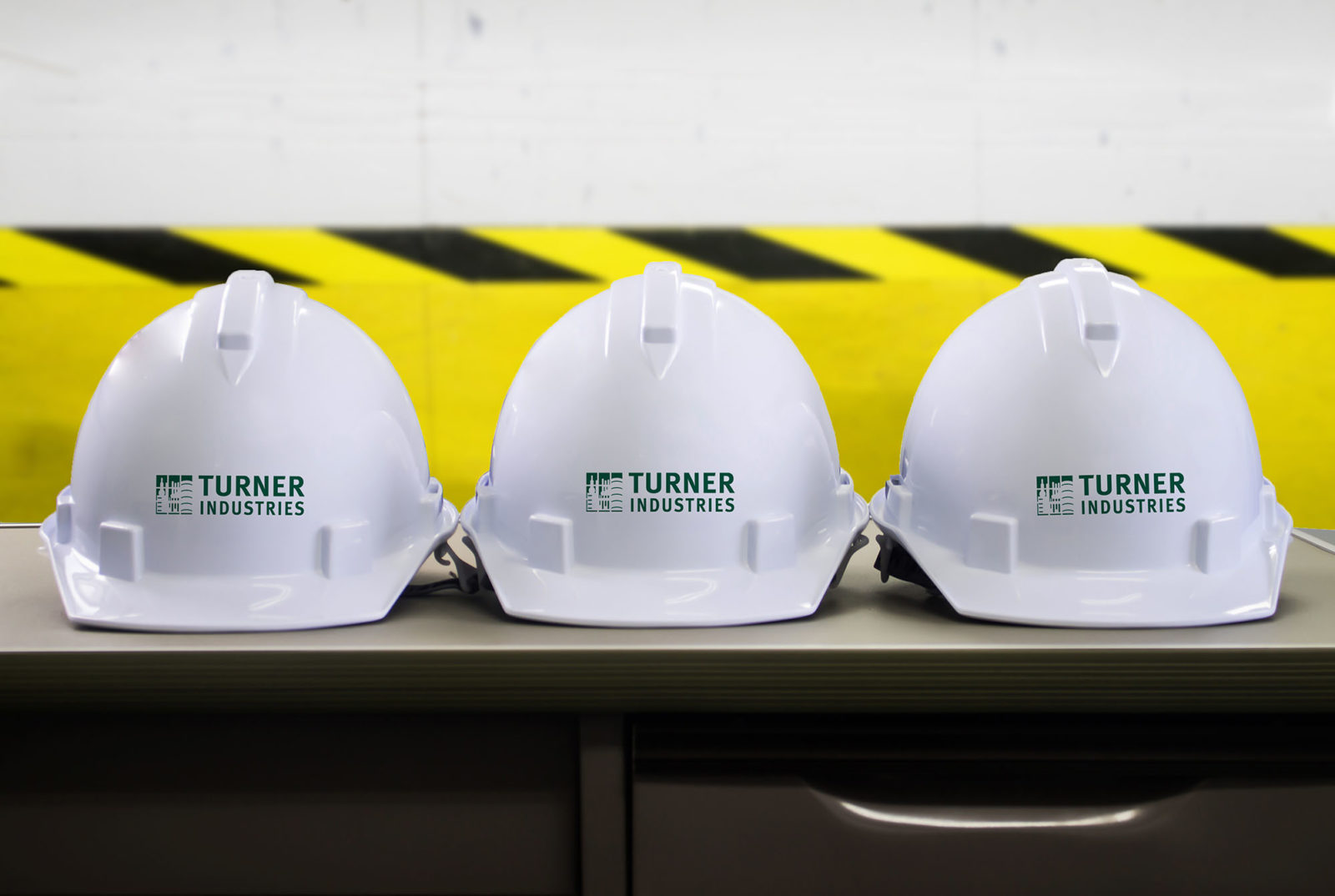 Several hard hats with Turner Industries.