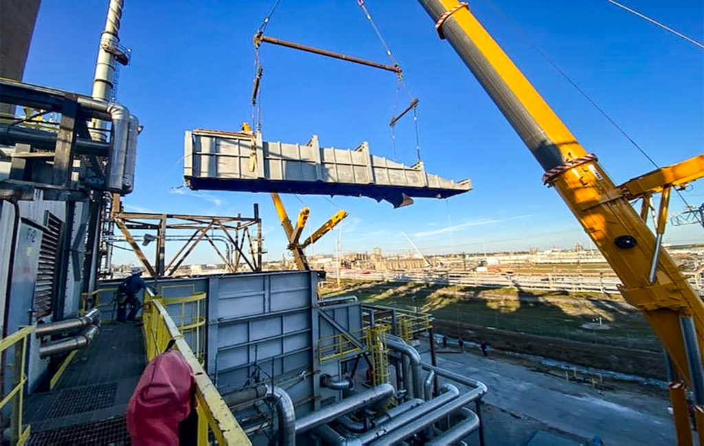 Yellow crane lifting heavy materials on an industrial worksite