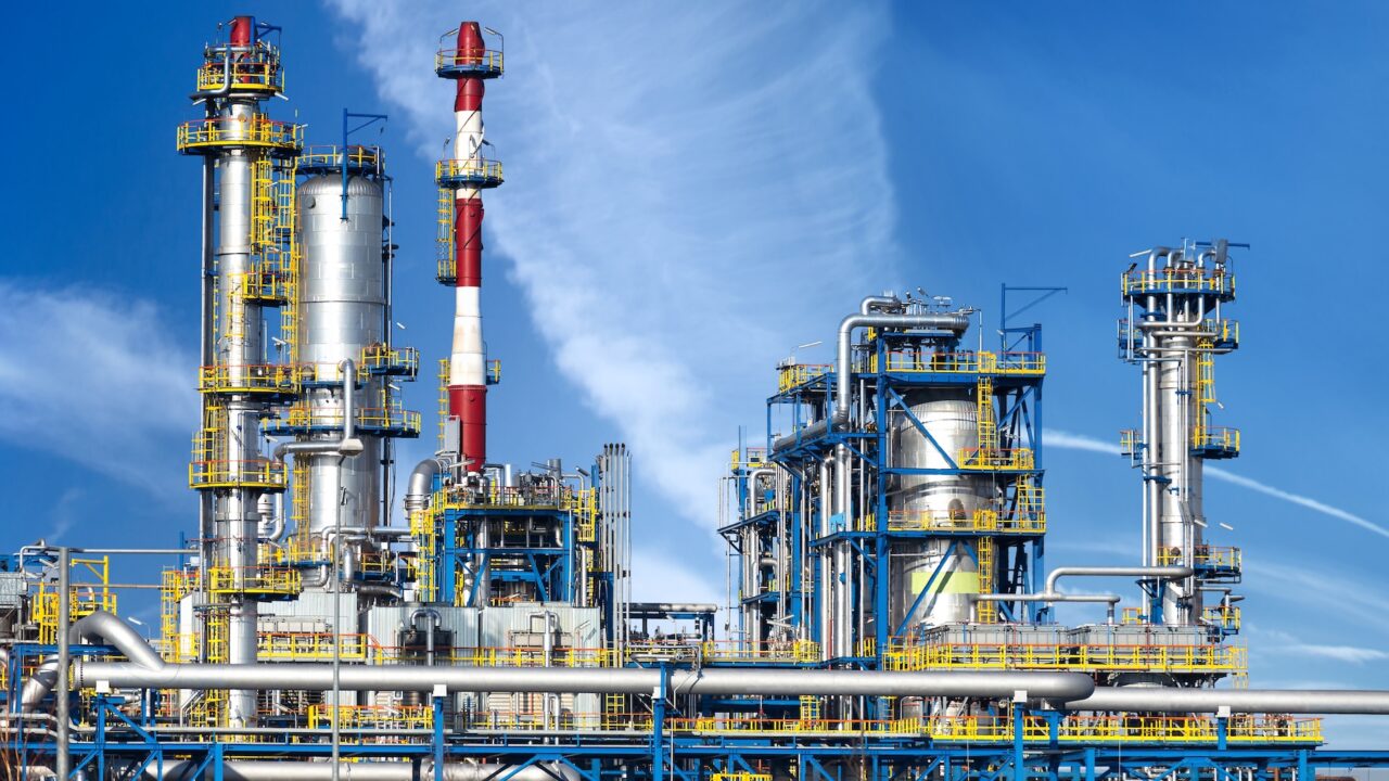 Petrochemical plant, oil refinery factory over blue sky.