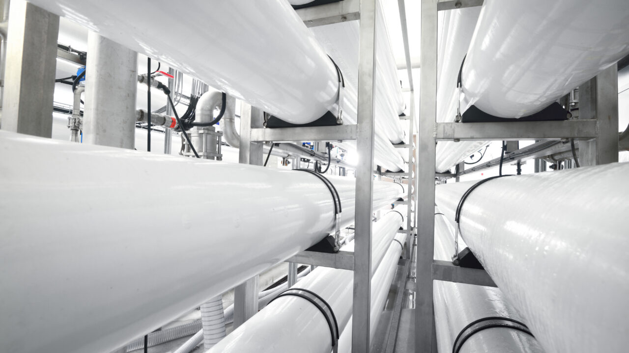 Large industrial water treatment and boiler room. White osmosis pipes.