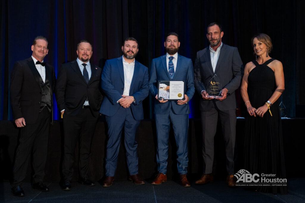 Six people in formal attire stand onstage; two hold awards. ABC Greater Houston logo is visible on the lower right corner.